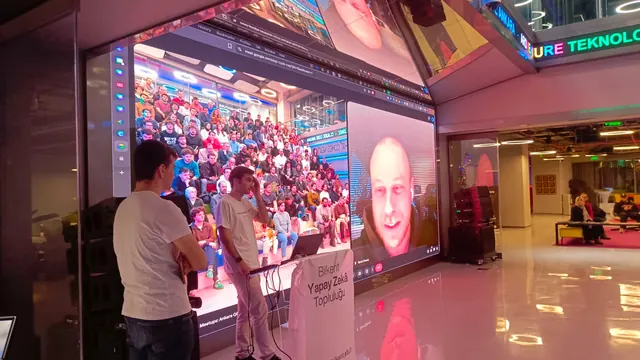 a meetup with a video call projected on a big screen