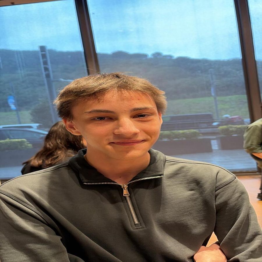 ahmet, smiling, in front of a window